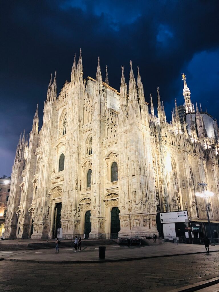 The iconic Duomo di Milano at night, an architectural marvel that awaits those relocating to Milan in 2023.