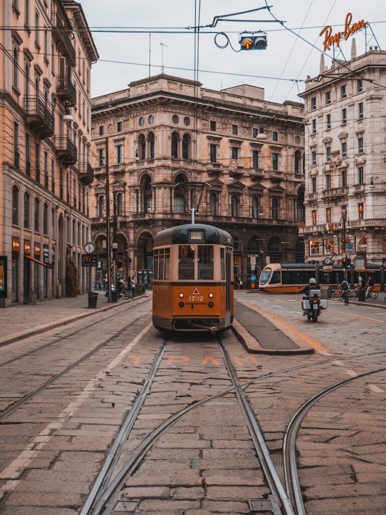 A tram running along the streets of Milan, showcasing the city's efficient public transportation system - a key aspect for those moving to Milan in 2023.